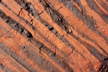 Demir ve bileşiklerini içeren doğal mineral oluşumları, bu oluşumlardan endüstriyel demir çıkarılması uygun olduğunda, böyle bir hacimde gerçekleşir. Taş ocağının taş dokusu. Ağır Sanayi için Madencilik - Demir cevheri içeren kaya dokusu ve