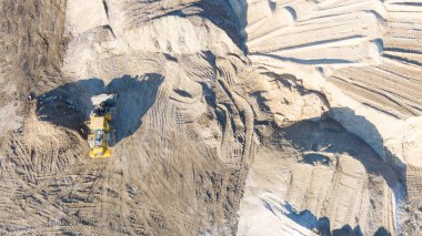 Kazıcı, minerallerin çıkarılması için toprak hareketinde çalışıyor. Kazıcı taş ocağında kum ve çakıl kazıyor. İnşaat alanında toprak çalışması sırasında ağır inşaat makineleri.