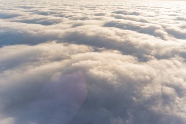 Özel bir jetin kokpitinden bulutların hava görüntüsü. Sisli bir gökyüzü. Güneşli gökyüzü arkaplanı