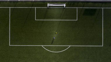 Yapay bir futbol sahasında beyaz işaretler.