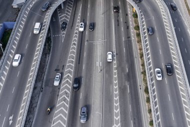 Merkezinde beyaz işaretli geniş bir asfalt yol. Büyük bir şehirde yüksek hızda giden yoğun bir araba akıntısı var. İHA 'dan alınan hava görüntüsü