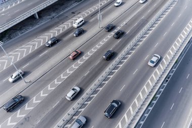 Merkezinde beyaz işaretli geniş bir asfalt yol. Büyük bir şehirde yüksek hızda giden yoğun bir araba akıntısı var. İHA 'dan alınan hava görüntüsü