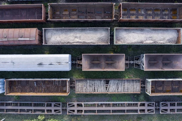 様々な貨物列車やワゴン鉄道駅でカラフルな貨物列車の飛行ドローンからの空中ビュー 貨物を鉄道で運ぶワゴン — ストック写真