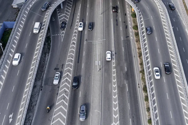 Merkezinde beyaz işaretli geniş bir asfalt yol. Büyük bir şehirde yüksek hızda giden yoğun bir araba akıntısı var. İHA 'dan alınan hava görüntüsü