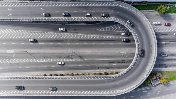 Merkezinde beyaz işaretli geniş bir asfalt yol. Büyük bir şehirde yüksek hızda giden yoğun bir araba akıntısı var. İHA 'dan alınan hava görüntüsü