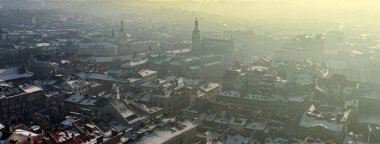 Kışın eski bir kasaba, güneş doğarken insanlar olmadan. Lviv şehrinin tarihi merkezi. Çatılar karla kaplı. İnsansız hava aracı, kışın, güneş doğarken, insansız eski bir kasabanın fotoğrafını çeker. Lviv şehrinin tarihi merkezi. Çatılar karla kaplı. D