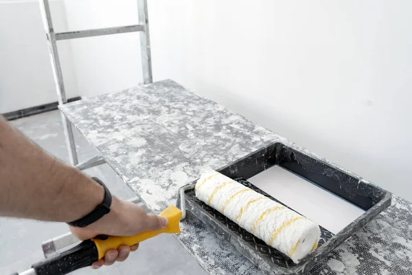Yeni bir binada apartman tadilatı. Duvar kağıtları için yüzey hazırlığı. Yüzey patinaj ve anti-mantar karışımıyla kaplanıyor.