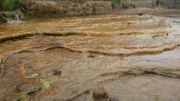 Draining sewage from pipe into river, pollution rivers and ecology