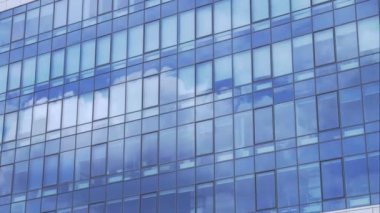 Modern bir ofis binasında bulutların yansıması. Cam cephe yapısının inşaatı