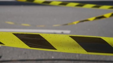 Dangerous stretch of road with damaged asphalt. The accident site is fenced off with black and yellow tape. The concept of repair or accident of sewerage, underground communications, water supply.