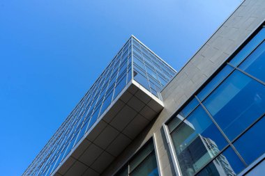 Modern office building facade. Tall business center with a glass facade. Construction of a glass facade structure. The glare of the sun on the glass wall of a skyscraper