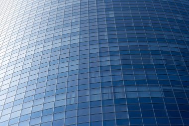 Modern office building facade. Tall business center with a glass facade. Construction of a glass facade structure. The glare of the sun on the glass wall of a skyscraper