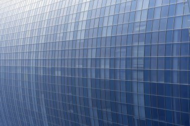Modern office building facade. Tall business center with a glass facade. Construction of a glass facade structure. The glare of the sun on the glass wall of a skyscraper