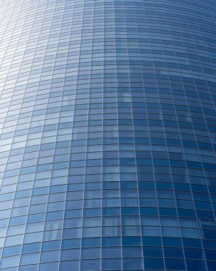 Modern office building facade. Tall business center with a glass facade. Construction of a glass facade structure. The glare of the sun on the glass wall of a skyscraper