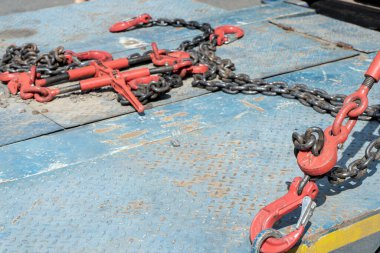 Crane hook, on which chains with hooks and fastening elements are attached. Lifting mechanism in production and warehouse close-up.