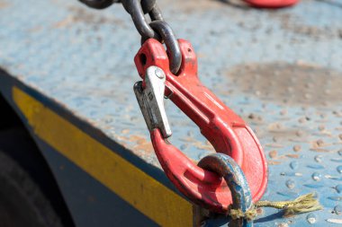 Crane hook, on which chains with hooks and fastening elements are attached. Lifting mechanism in production and warehouse close-up.