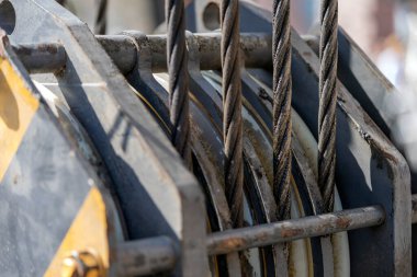 Unloading cargo and loading cargo with a crane. Crane boom and hook against the sky with engineering details and knots.