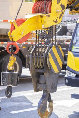 Unloading cargo and loading cargo with a crane. Crane boom and hook against the sky with engineering details and knots.