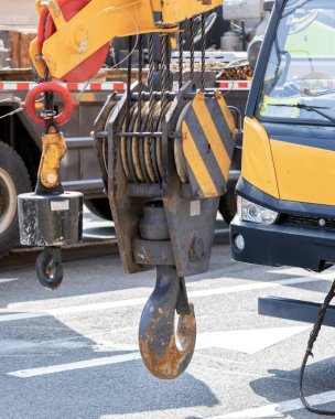 Unloading cargo and loading cargo with a crane. Crane boom and hook against the sky with engineering details and knots.