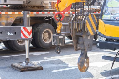 Unloading cargo and loading cargo with a crane. Crane boom and hook against the sky with engineering details and knots.