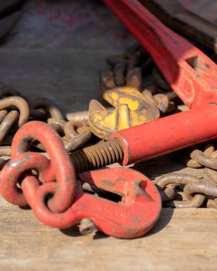 Crane hook, on which chains with hooks and fastening elements are attached. Lifting mechanism in production and warehouse close-up.