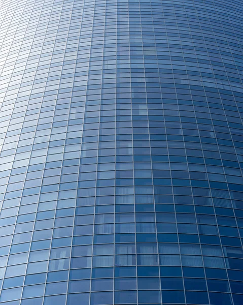 Modern office building facade. Tall business center with a glass facade. Construction of a glass facade structure. The glare of the sun on the glass wall of a skyscraper