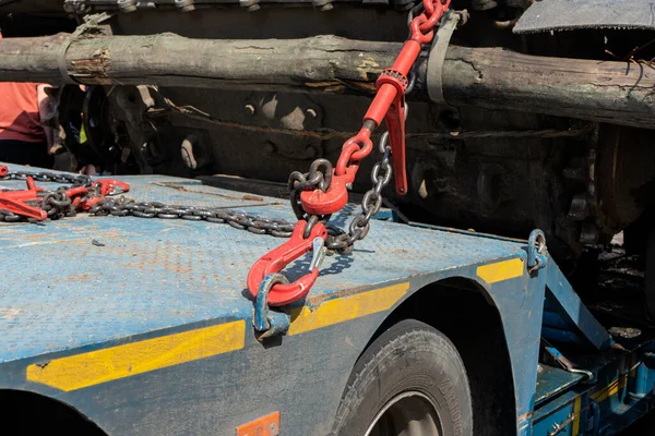 Crane hook, on which chains with hooks and fastening elements are attached. Lifting mechanism in production and warehouse close-up.