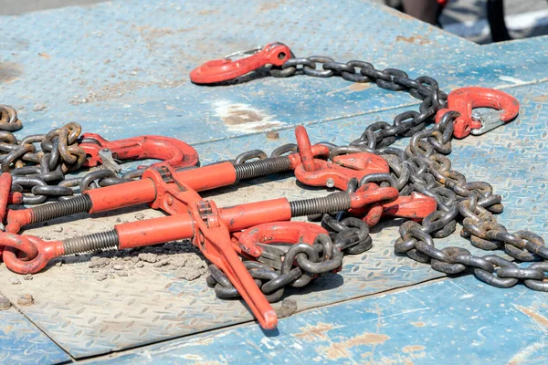 Crane hook, on which chains with hooks and fastening elements are attached. Lifting mechanism in production and warehouse close-up.