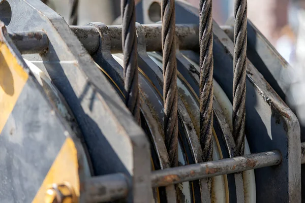 Unloading cargo and loading cargo with a crane. Crane boom and hook against the sky with engineering details and knots.