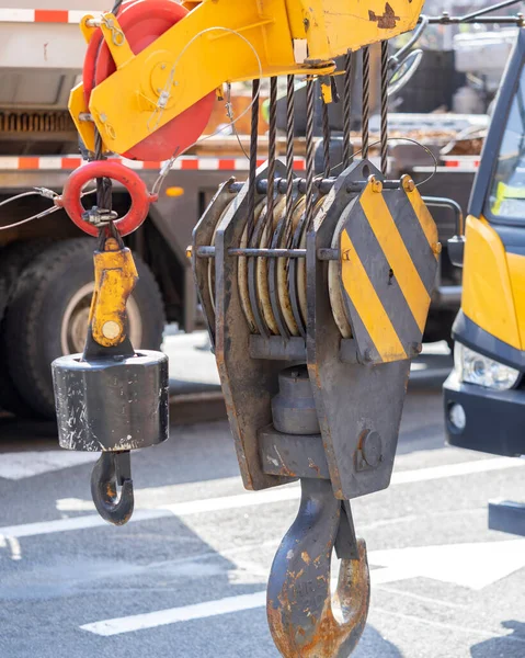 Unloading cargo and loading cargo with a crane. Crane boom and hook against the sky with engineering details and knots.