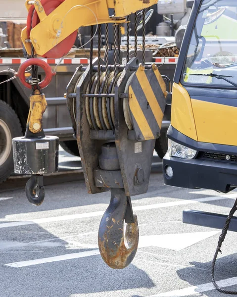 Unloading cargo and loading cargo with a crane. Crane boom and hook against the sky with engineering details and knots.