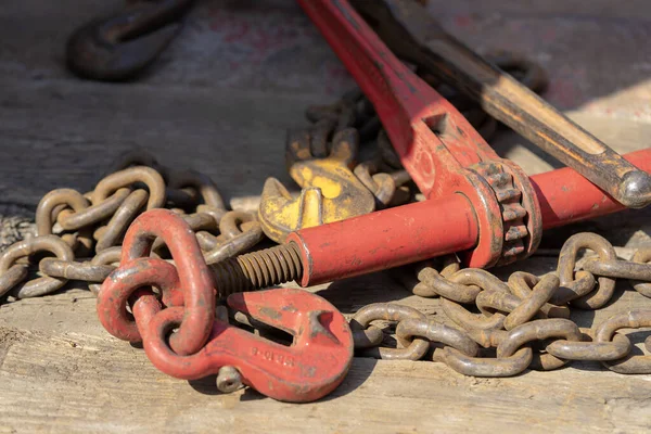 Crane hook, on which chains with hooks and fastening elements are attached. Lifting mechanism in production and warehouse close-up.