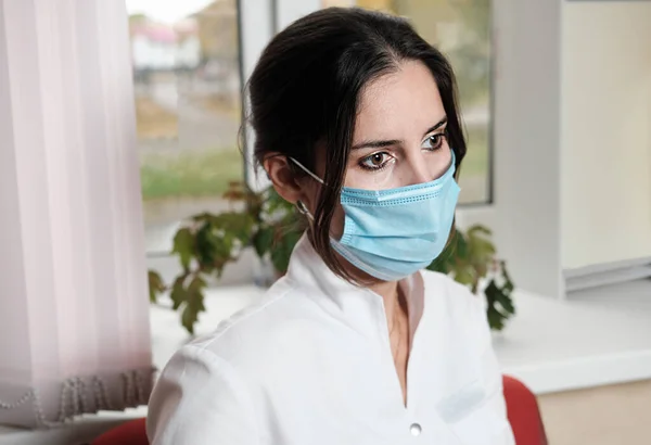 Zmęczona Kobieta Pielęgniarka Nosząca Medyczną Nieformę Maskę Twarzy Siedząca Przed — Zdjęcie stockowe