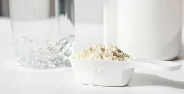 Κολλαγόνο ή πεπτίδια πρωτεϊνών σε σκόνη σε λευκό τραπέζι. πρωτεΐνη σε σκόνη για την παρασκευή ροφήματος ορού γάλακτος ή κοκτέιλ κολλαγόνου για αρθρώσεις και όμορφη επιδερμίδα — Φωτογραφία Αρχείου