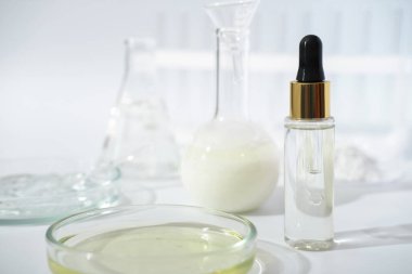 laboratory dishes and glassware on a lab table. fermentation, fermented beauty skin care. dropper bottle of solution or serum for anti age treatment clipart