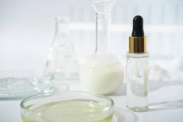 laboratory dishes and glassware on a lab table. fermentation, fermented beauty skin care. dropper bottle of solution or serum for anti age treatment