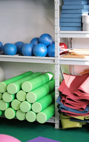 Pilates e equipamentos de ioga em um ginásio de fitness. bolas, tapetes e rolos de espuma nas prateleiras. alongamento e relaxamento — Fotografia de Stock