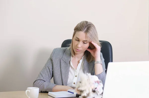 Zamyślona blondynka bizneswoman patrząc na pamiętnik, siedzi w biurze, wyczerpany zdenerwowany pracownik, mając problem z trudnym projektem online. — Zdjęcie stockowe