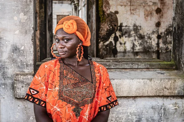 Afrikka Nainen Oranssissa Puvussa Päähine Seisoo Vanhan Rakennuksen Vieressä Takoradi — kuvapankkivalokuva