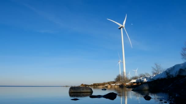 スウェーデンバルト海による美しい青空の下 月を背景にゆっくりと回転する風力タービン2022年3月 — ストック動画