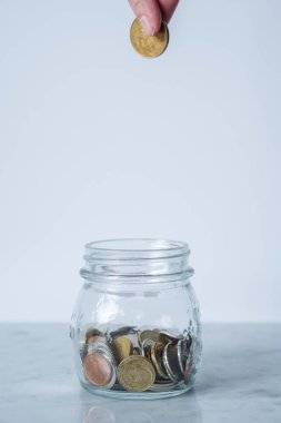 Yatırım Parası kavramı - Yeni Zelanda Sikkesini Kopya Boşluğu ile Yarısı Dolu Tasarruf kavanozuna Kişi