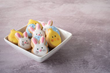 Seçici Odaklı Paskalya Kurabiyeleri Kasesi ve Işık Arkaplanı Uzayı Kopyala