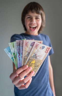 Bir avuç dolusu Yeni Zelanda Banknotuyla karışık ırk genci Mutlu Yüzlü Seçici Odaklanma