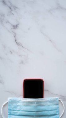 Üzerine Masa Üzerinde Bir Maske Takan Cep Telefonu - Kopyalama Uzayı ile Salgın Dikey Sırasındaki Güvenlik Konsepti