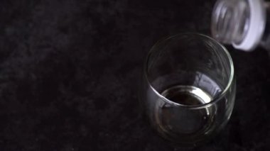 Yakın çekim, Karanlık Arkaplan 'ın tepesinden kadehe dökülen Kola içeceği Yavaş çekim
