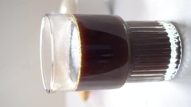 Milk Being Poured onto Large Coffee Glass on Light Background Vertical Footage 