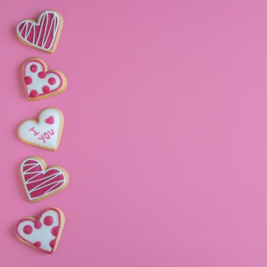 Line of Heart Shaped Valentine Cookies on Pink Background with Copy Space