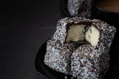 Chocolate Lamingtons on a Plate with Tea on a Table with Copy Space