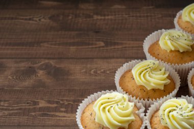 Batch of Lemon and Poppy Seed Muffins on Wooden Table with Selective Focus and Copy Space