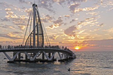 Ocean pier in setting sun clipart
